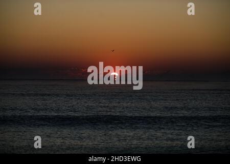 Vagues douces tandis que le soleil se lève sur la mer Noire dans la station balnéaire d'Obzor en Bulgarie lors d'une journée d'été calme et chaude. Banque D'Images