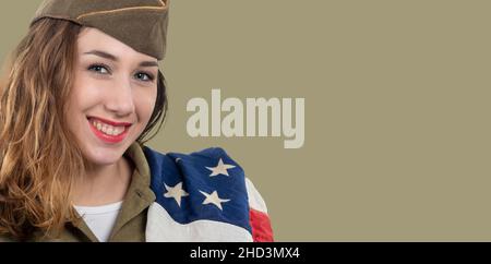 Jolie jeune femme en uniforme ww2 us avec un drapeau américain Banque D'Images