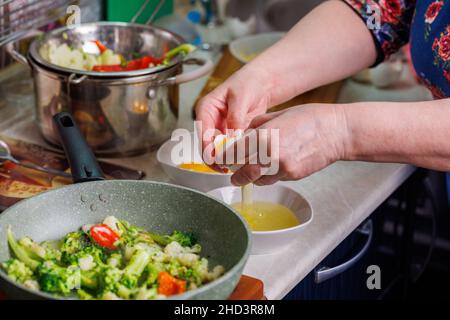 femme caucasienne sérante mains cassant blanc oeuf de poulet au-dessus du bol blanc Banque D'Images