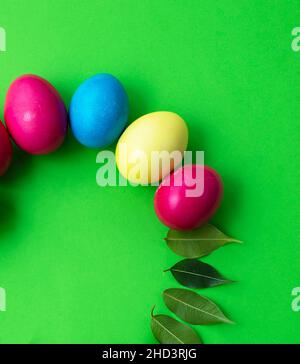 Thèmes de Pâques.Œufs colorés et feuilles vertes.Copier l'espace pour le texte. Banque D'Images