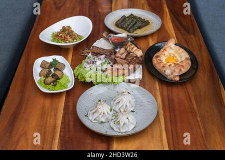 Fête festive avec différents plats de Géorgie, d'Arménie et de Russie.Cuisine caucasienne.Divers plats délicieux sur la table en bois. Banque D'Images