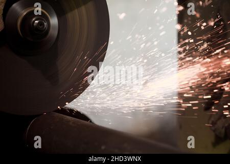 Des étincelles survolent la machine pour le traitement des métaux des aiguilles. Fond de l'usine métallurgique.Fabrication de pièces finies pour le concept de production industrielle Banque D'Images