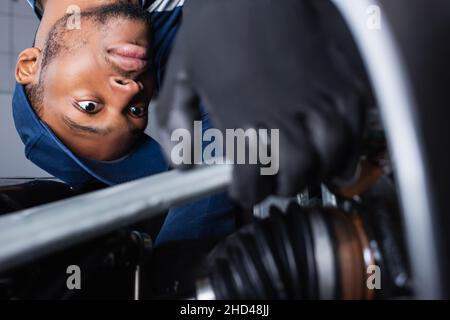 le contremaître afro-américain fait le diagnostic de la voiture sur un premier plan flou Banque D'Images