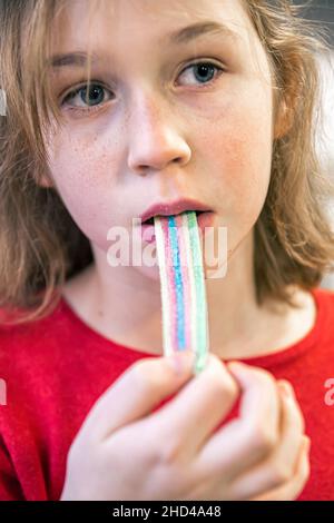 Gros plan, petite fille mangeant des bonbons délicieux. Banque D'Images