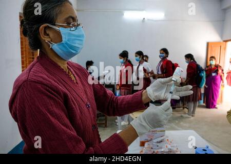 Kolkata, Inde.03rd janvier 2022.Un professionnel de la santé se prépare à administrer une dose de vaccin Covaxin mis au point par Bharat Biotech à un étudiant de la Barasat Girls High School, à Kolkata.dans un contexte d'augmentation considérable des cas de COVID-19 dans le Bengale occidental, la campagne de vaccination pour les personnes du groupe d'âge 15-18 ans commence le 3rd janvier.Crédit : SOPA Images Limited/Alamy Live News Banque D'Images