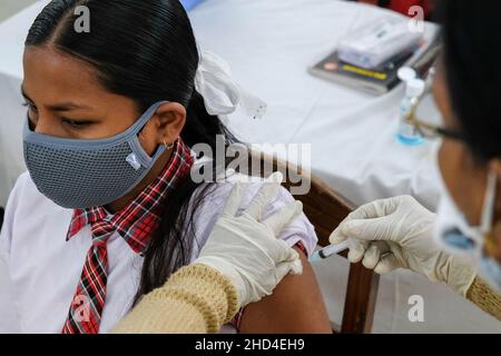 Kolkata, Inde.03rd janvier 2022.Un travailleur de la santé administre une dose de vaccin Covaxin mis au point par Bharat Biotech à un étudiant de la Barasat Girls High School, à Kolkata.en raison de la forte augmentation des cas de COVID-19 dans le Bengale occidental, la campagne de vaccination pour les personnes du groupe d'âge 15-18 ans commence le 3rd janvier.Crédit : SOPA Images Limited/Alamy Live News Banque D'Images