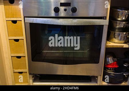 Porte cassée sur un four en acier inoxydable dans une cuisine maison Banque D'Images