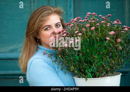 Une belle fille tient un grand bouquet de fleurs et souriant.Bonne jeune femme dans la ville. Banque D'Images