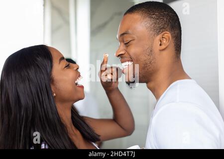 Gros plan sur le couple afro-américain heureux s'amuser dans la salle de bains Banque D'Images