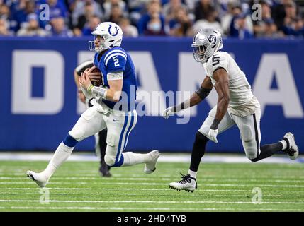Indianapolis, Indiana, États-Unis.02nd janvier 2022.Le quarterback des Indianapolis Colts Carson Wentz (2) joue avec le ballon tandis que le linebacker des Las Vegas Raiders Divine Deablo (5) poursuit pendant l'action de football de la NFL entre les Las Vegas Raiders et les Indianapolis Colts au stade Lucas Oil à Indianapolis, Indiana.Las Vegas a battu Indianapolis 23-20.John Mersiits/CSM/Alamy Live News Banque D'Images
