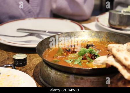 Un bol en métal de poulet au curry dans un restaurant punjabi Banque D'Images