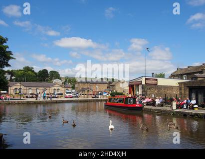 Touristes profitant du soleil au bassin du canal de Skipton dans le Yorkshire, Angleterre. Banque D'Images