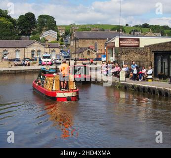 Touristes regardant un bateau à rames et profitant du soleil au bassin du canal de Skipton dans le Yorkshire, en Angleterre. Banque D'Images