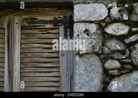 Ancienne maison rurale traditionnelle ancienne fenêtre en bois avec volets sur un mur en pierre fait à la main à Leonidio, Arcadia Péloponnèse, Grèce. Banque D'Images