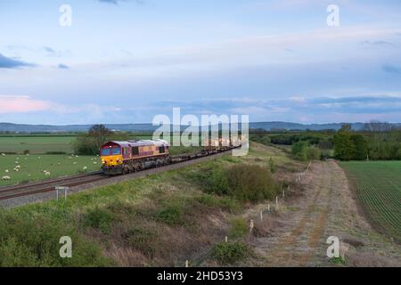 DB CARGO EWS livraison classe 66 locomotive diesel transportant un train de marchandises de conteneurs-citernes ISO à travers la campagne Banque D'Images