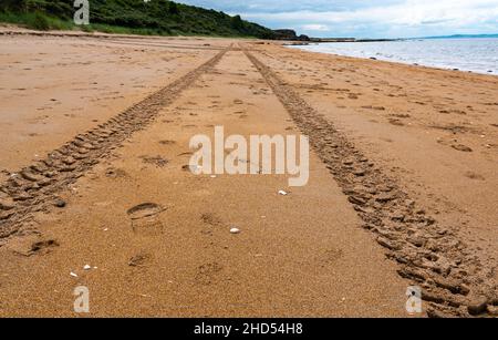 Pistes de pneus menant à la distance sur une plage vide déserte, Gullane, East Lothian, Écosse, Royaume-Uni Banque D'Images