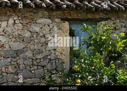 Ancienne maison rurale traditionnelle avec un mur en pierre fait à la main et un ancien toit en tuiles d'argile à Leonidio, Arcadia Péloponnese, Grèce. Banque D'Images