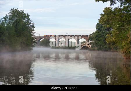 GB Railfreight classe 66 locomotive diesel croisant Dutton viaduc sur la ligne principale de la côte ouest à Cheshire avec un train de marchandises transportant des agrégats. Banque D'Images