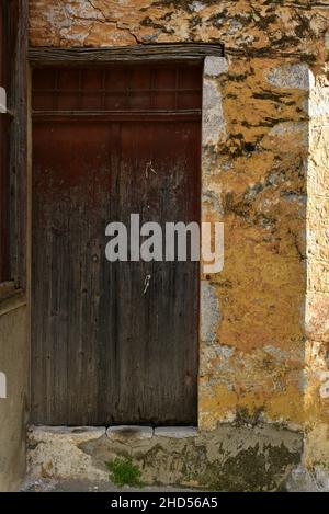 Ancienne porte en bois sur un mur en pierre patiné fait à la main à Leonidio, Arcadia Péloponnese, Grèce. Banque D'Images