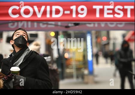 Un homme regarde l'Empire State Building alors qu'il se trouve à côté d'un site d'essai de la COVID-19 sur 5th Avenue, New York, NY, le 3 janvier 2022.La ville de New York est actuellement en train de voir une poussée de COVID-19 alimentée par la variante Omicron et connaît un taux de positivité de 23%.(Photo par Anthony Behar/Sipa USA) Banque D'Images