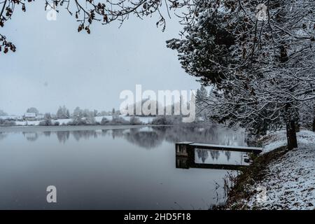 Jetée en bois sur le lac avec de la neige fraîche.étang d'hiver avec une petite jetée le matin brumeux.paysage nuageux Foggy reflété dans l'eau.Blanc campagne d'hiver Banque D'Images