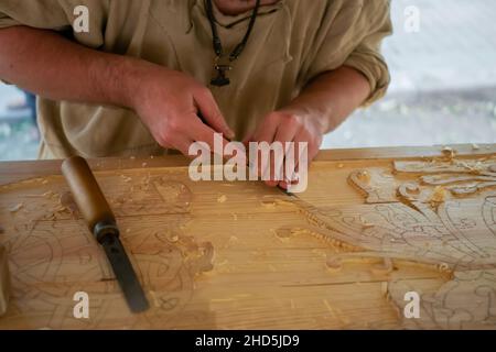 Carpenter sculptant du bois avec burin au festival medival - gros plan Banque D'Images