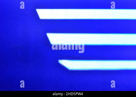 Une superbe image abstraite créée sur un mur peint en bleu avec la lumière du soleil en streaming dans des motifs de soleil chevrons au-dessus de la tête pour un concept moderne Banque D'Images