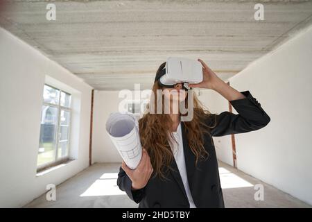 Femme de créateur avec des dessins utilisant des lunettes VR à l'intérieur Banque D'Images