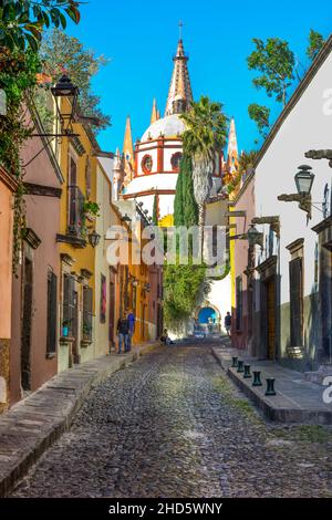 L'étroite rue Cobblestone Aldama offre une vue sur le Parroquia San Miguel de Allende Archangel Church Dome à côté des maisons et des trottoirs à San Miguel Banque D'Images