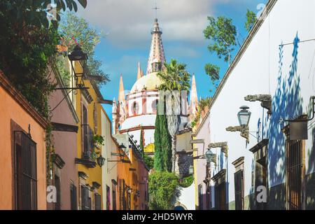 Lanternes ornementales et dessins uniques pour les canales parmi les maisons colorées sur la rue Aldama avec vue sur le Dôme pour la Parroquia à SMA, Mexique Banque D'Images