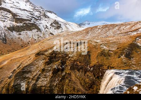 L'eau glacée commence sa chute de 60 mètres au-dessus de la chute d'eau Skogafoss dans le pays islandais de thje Banque D'Images