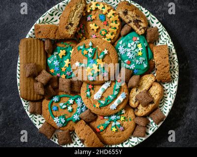 Délicieux petits gâteaux faits maison, plat.Pile de différents biscuits décorée de sucre glaçure sur l'assiette.Vue de dessus de divers desserts, délicieux repas pour pa Banque D'Images