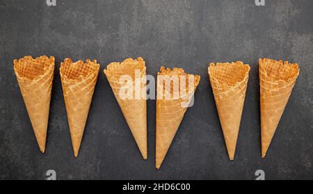 Mise à plat des glaces collection sur pierre sombre contexte . Croustillant blanc ice cream cone avec copie espace pour les dragées menu design. Banque D'Images