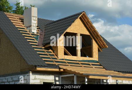 Une maison en construction avec un gros plan de la construction de la toiture sur la scène de la toiture charpente au-dessus d'un pare-vapeur, carreaux métalliques et des solins Banque D'Images