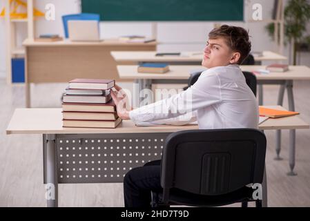 Élève de sexe masculin assis dans le classrom Banque D'Images