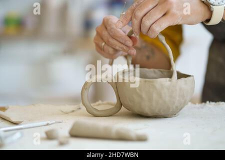 Occupation artisanale pour se détendre après le travail.Gros plan des mains femelles travaillant avec de l'argile brute Banque D'Images
