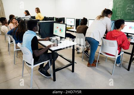 Jeunes élèves utilisant des ordinateurs à l'intérieur de la classe d'affaires à l'école - Focus sur la main de gars africains Banque D'Images