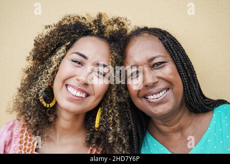 Bonne mère africaine et fille souriant sur l'appareil photo - Focus sur les visages Banque D'Images