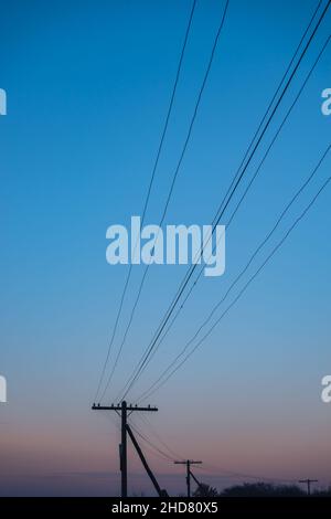 Lever de soleil coloré au-dessus de la avec arbres et poteau électrique. Banque D'Images