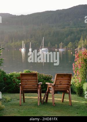 Chaises de jardin dans le paysage de jardin tempéré de Plockton et Loch Carron à Lochalsh, Wester Ross, West Highlands Ecosse Royaume-Uni Banque D'Images