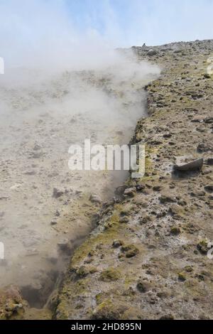 Vapeur d'un fumarale au sommet du volcan Etna, Italie. La vapeur blanche provient d'une fissure, entourée de roche et de soufre jaune minéral d Banque D'Images