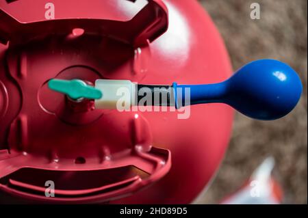 Accent sélectif sur le bord d'un ballon gonflable fixé à un réservoir d'hélium. Banque D'Images