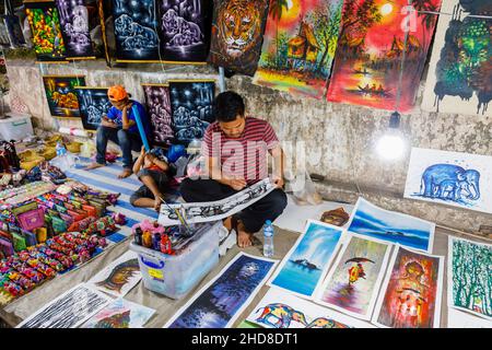 Un détenteur local peint une photo souvenir dans un stand dans le marché nocturne de la rue piétonne dans le centre de Luang Prabang, dans le nord du Laos, dans le sud-est de l'Asie Banque D'Images