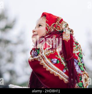 Portrait de la belle petite fille enfant pendant la promenade en forêt.Elle portait le style russe ancien en foulard rouge. Banque D'Images