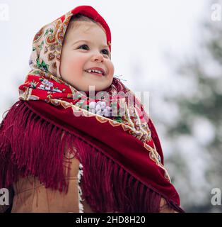 Portrait de la belle petite fille enfant pendant la promenade en forêt.Elle portait le style russe ancien en foulard rouge. Banque D'Images