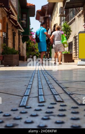 Une forme d'installation publique sur le trottoir est des carreaux disposés en une ligne, pour aider les personnes aveugles à marcher dans la vieille ville d'Alanya, Turquie.Sélectionnez la mise au point. Banque D'Images