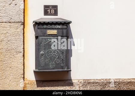 Une ancienne boîte aux lettres noire sur la rue à l'entrée d'un immeuble résidentiel dans la vieille ville d'Antalya, Turquie - 09.01. 2021. Banque D'Images