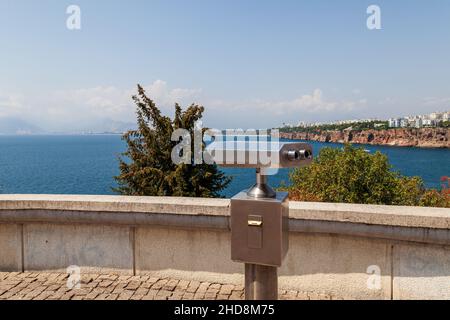 Gris métal télescope à monnayeur isolée à été belle vue panoramique à cityscape, ciel bleu et l'eau de mer. La Turquie, la ville d'Antalya. Banque D'Images