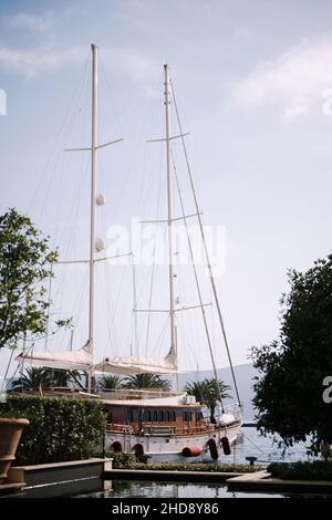 Magnifique yacht se trouve dans le port entouré d'arbres verts Banque D'Images