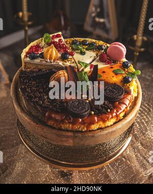 Différentes tranches de divers gâteaux, faisant une seule tarte entière sur un support à gâteau Banque D'Images